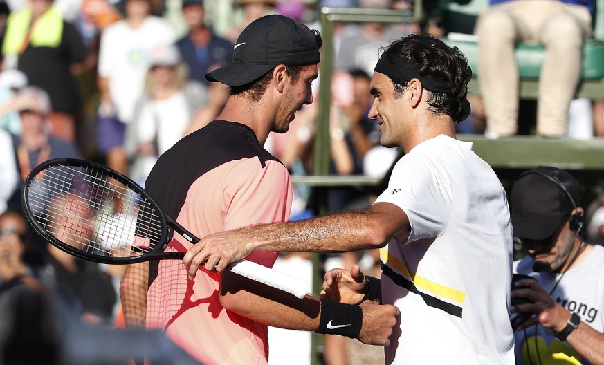 epa06627934 Thanasi Kokkinakis of Australia (L) and Roger Federer of Switzerland (R) meet at the net following their second round match at the Miami Open tennis tournament on Key Biscayne, Miami, Flor ...