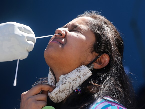 epa09634034 A girl undergoes a nasal test to detect Covid-19 at a Hostel in Bangalore, India, 10 December 2021. The Karnataka State Chief Minister and the Technical Advisory Committee announced that s ...