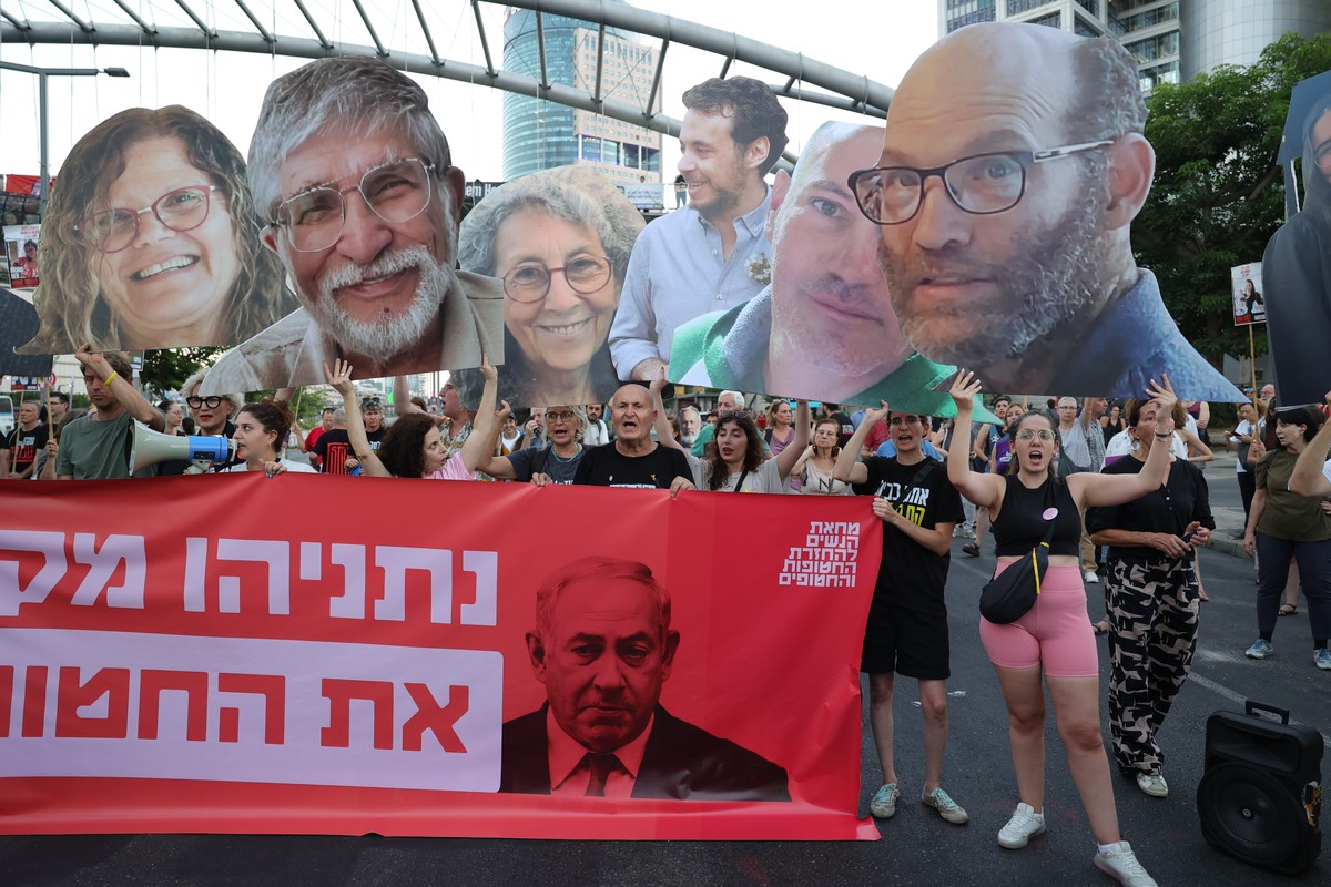 epa11556776 Families of Israeli hostages held by Hamas in Gaza and their supporters hold pictures of hostages with a banner reading 'Netanyahu sacrifices the lives of the hostages' as they c ...