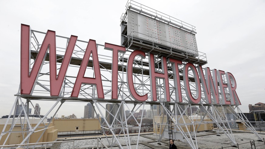In this Wednesday, Dec. 9, 2015, photo, the iconic Watchtower sign is seen on the roof of 25-30 Columbia Heights, the current world headquarters of the Jehovah&#039;s Witnesses, in the Brooklyn boroug ...
