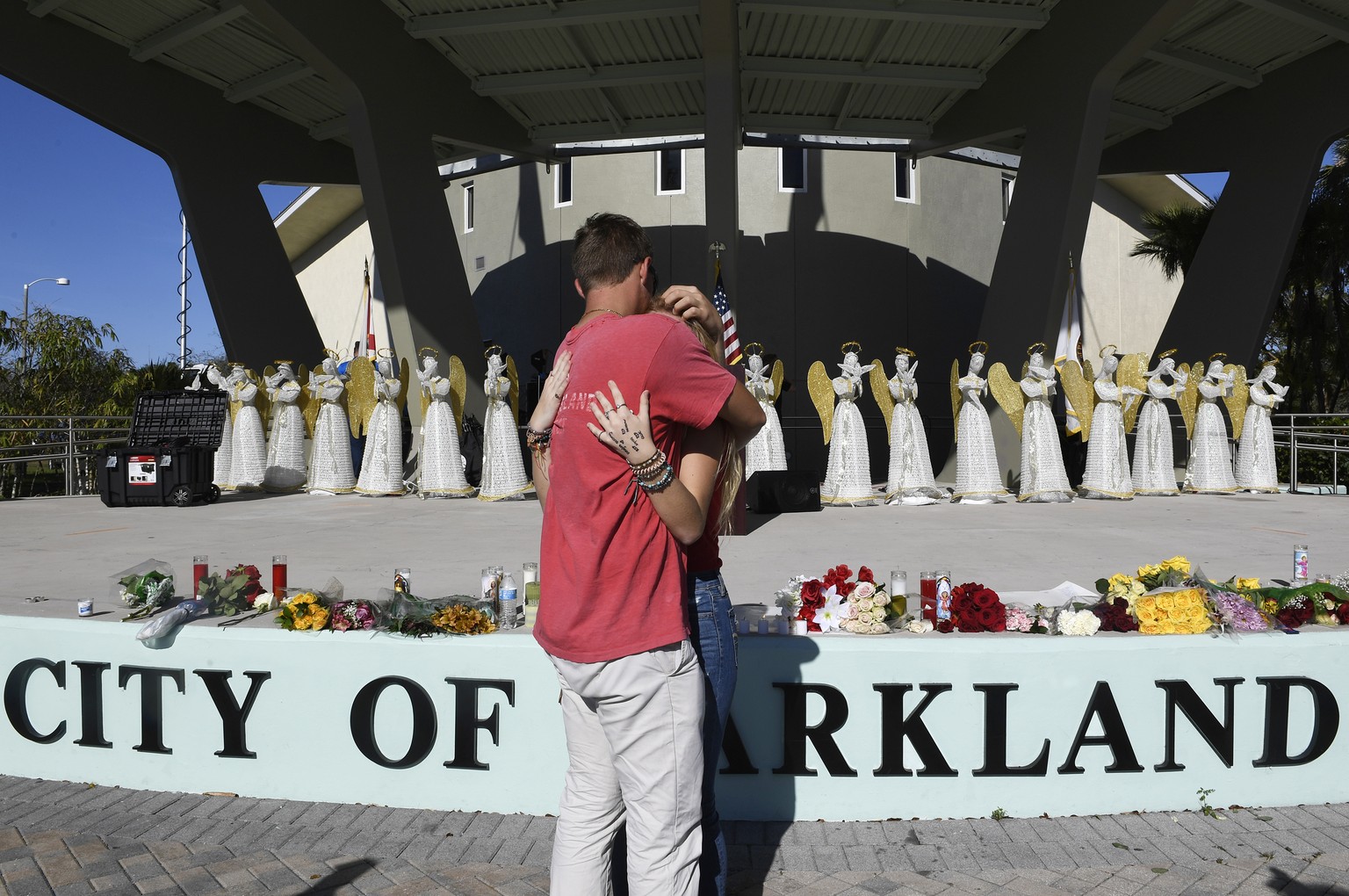 Zack King, left, comforts friend Mychal Bradley in front of 17 angels representing those who died in Wednesday&#039;s shooting at Marjory Stoneman Douglas High School Thursday, Feb. 15, 2018, in Parkl ...