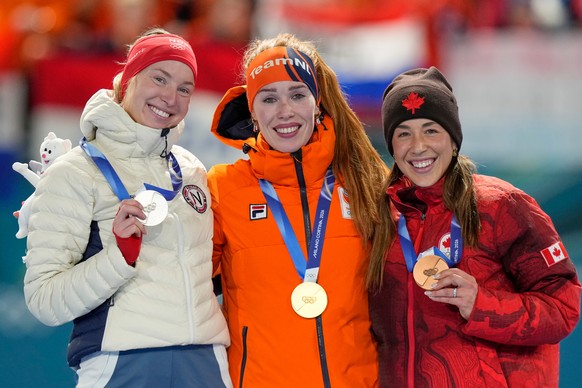Antoinette Rijpma-de Jong of the Netherlands, center and gold medal, Ragne Wiklund of Norway, left and silver medal, and Valerie Maltais of Canada, right and bronze medal, celebrate on the podium of t ...