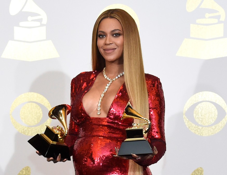 FILE - In this Feb. 12, 2017 file photo, Beyonce poses in the press room with the awards for best music video for &quot;Formation&quot; and best urban contemporary album for &quot;Lemonade&quot; at th ...