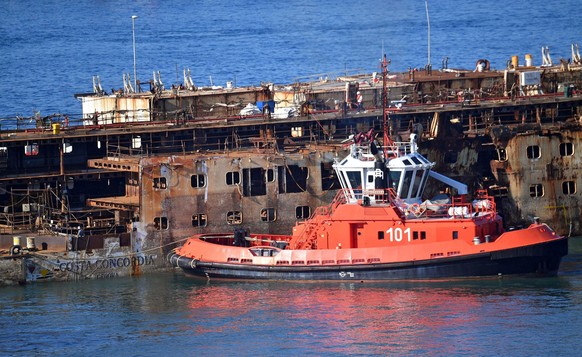 epa05518059 The wreck of cruise liner Costa Concordia is towed by five tugboats during its final journey inside the port of Genoa, Italy, 01 September 2016. The cruise liner, which capsized on 13 Janu ...