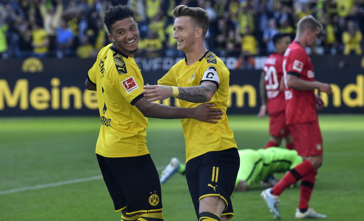 Dortmund's scorer Marco Reus, center, celebrates with Dortmund's Jadon Sancho, left, after he scored his side's second goal during the German Bundesliga soccer match between Borussia Do ...