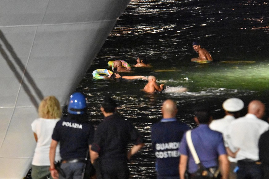 epa06972618 Pro-migrant demonstrators try to reach by swimming the Italian Coast Guard ship Diciotti in the port of Catania, Italy, 25 August 2018. The vessel arrived between Sunday and Monday with 17 ...