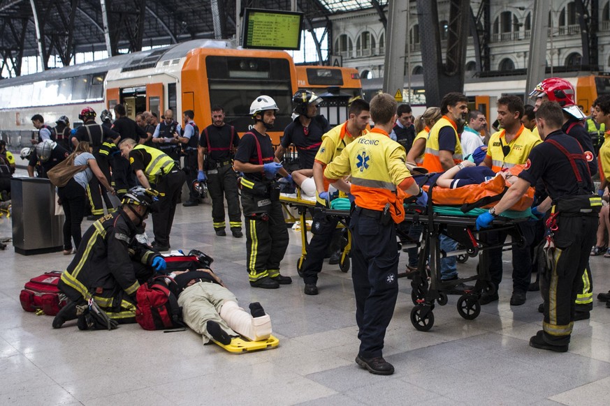 epa06113944 Spanish firefighters and paramedics treat injured people at Francia Railway Station in Barcelona, northeastern Spain, 28 July 2017. According to reports, at least 48 people were wounded, f ...