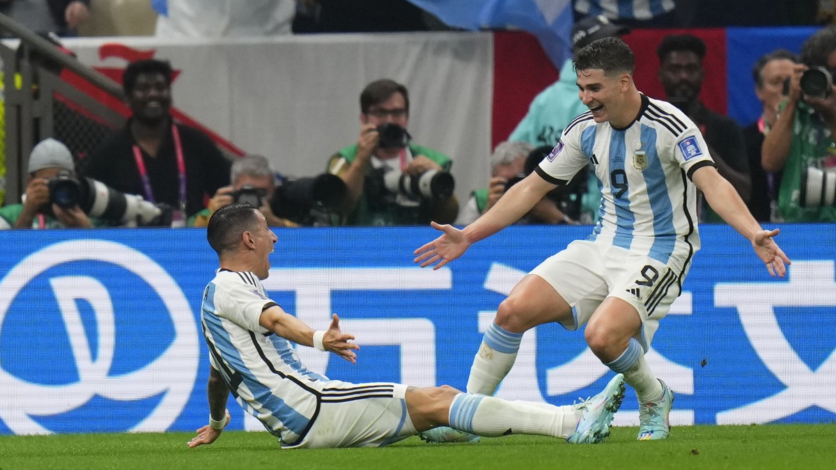 Argentina's Angel Di Maria, left and Julian Alvarez celebrate after a goal during the World Cup final soccer match between Argentina and France at the Lusail Stadium in Lusail, Qatar, Sunday, Dec ...