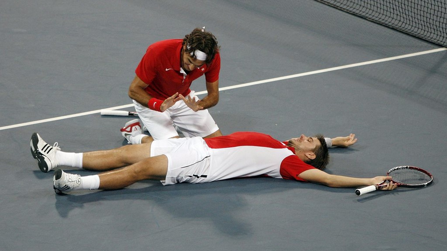 Roger Federer, left, and Stanislas Wawrinka of Switzerland react after winning their match against Bob Bryan and Mike Bryan during the semi final of the men's double tennis at the Beijing 2008 Olympic ...