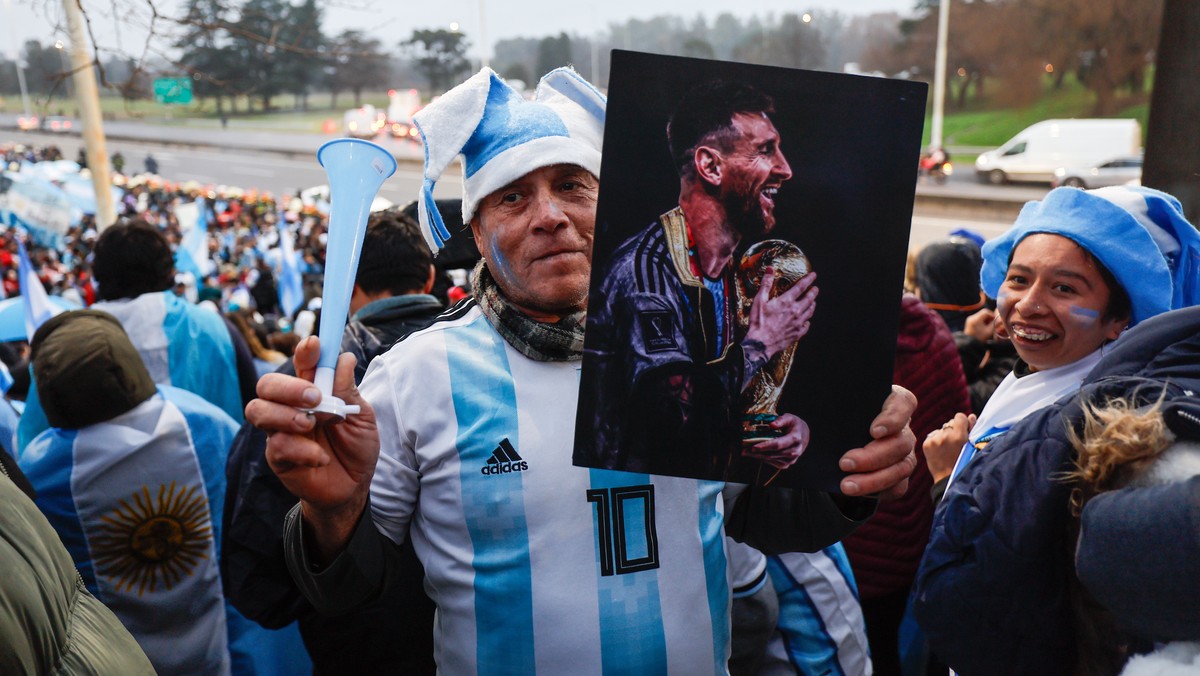 epa13123938 A person holds up a picture of Lionel Messi as fans welcome the national team following its return from the FIFA World Cup 2026 in Ezeiza, Buenos Aires province, Argentina, 20 July 2026. A ...