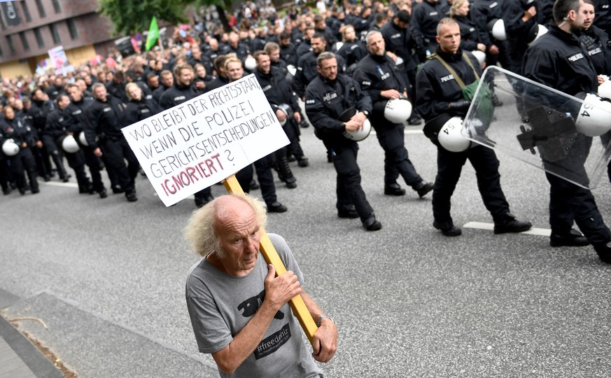 epa06075960 A protester marches along with riot policemen while holding a placard reading &#039;What happens to the constitutional state if police ignores court decisions&#039; in the &#039;Unlimited  ...