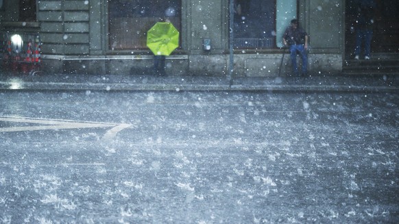 Passanten rennen durch den durch den Regen, fotografiert am Dienstag, 2. Juni 2026 waehrend eines Gewitters am Hischengraben in Bern. (KEYSTONE/Christian Beutler)