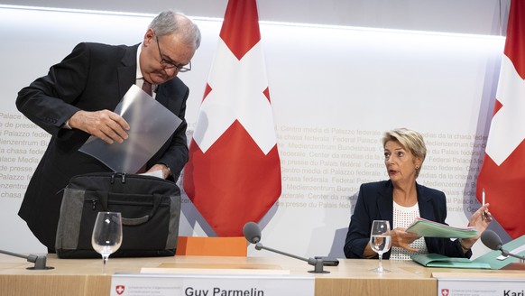 Bundespraesidentin Karin Keller-Sutter, rechts, und Bundesrat Guy Parmelin sprechen an einer Medienkonferenz ueber die Handelsbeziehungen mit den USA, am Donnerstag, 7. August 2025, in Bern. (KEYSTONE ...