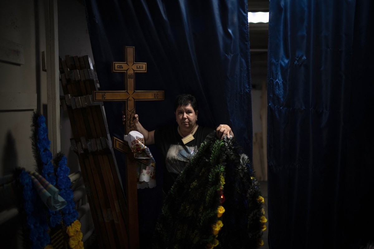 Svitlana Ostapenko, directrice du funérarium de Soumy, prépare une croix funéraire et des couronnes pour l'enterrement d'un jeune soldat récemment tué au front à Soumy, dans le nord-est de l ...