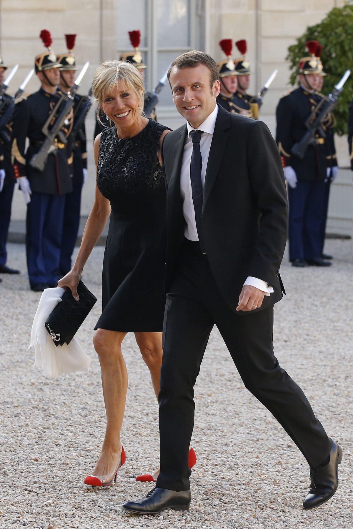 epa04780789 French Economy Minister Emmanuel Macron (R) arrives with his wife Brigitte Trogneux (L) at the Elysee Palace for a state diner in the honor of Spain's King Felipe VI and Queen Letizia ...