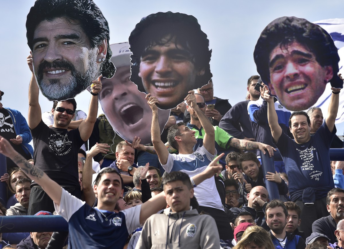 Fans of the Gimnasia y Esgrima La Plata soccer team hold up photos of their team's new head coach, Diego Maradona, at a local tournament soccer match against Racing Club at Juan Carmelo Zerillo s ...