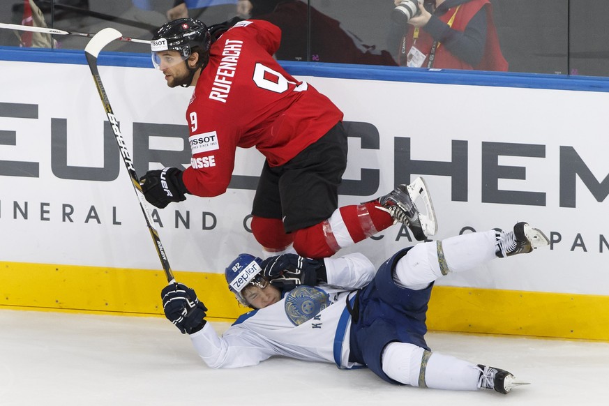 Switzerland&#039;s Thomas Ruefenacht, top, passes over Kazakhstan&#039;s Mikhail Rakhmanov, down, during the 2014 IIHF Ice Hockey World Championships preliminary round game Switzerland vs Kazakhstan,  ...