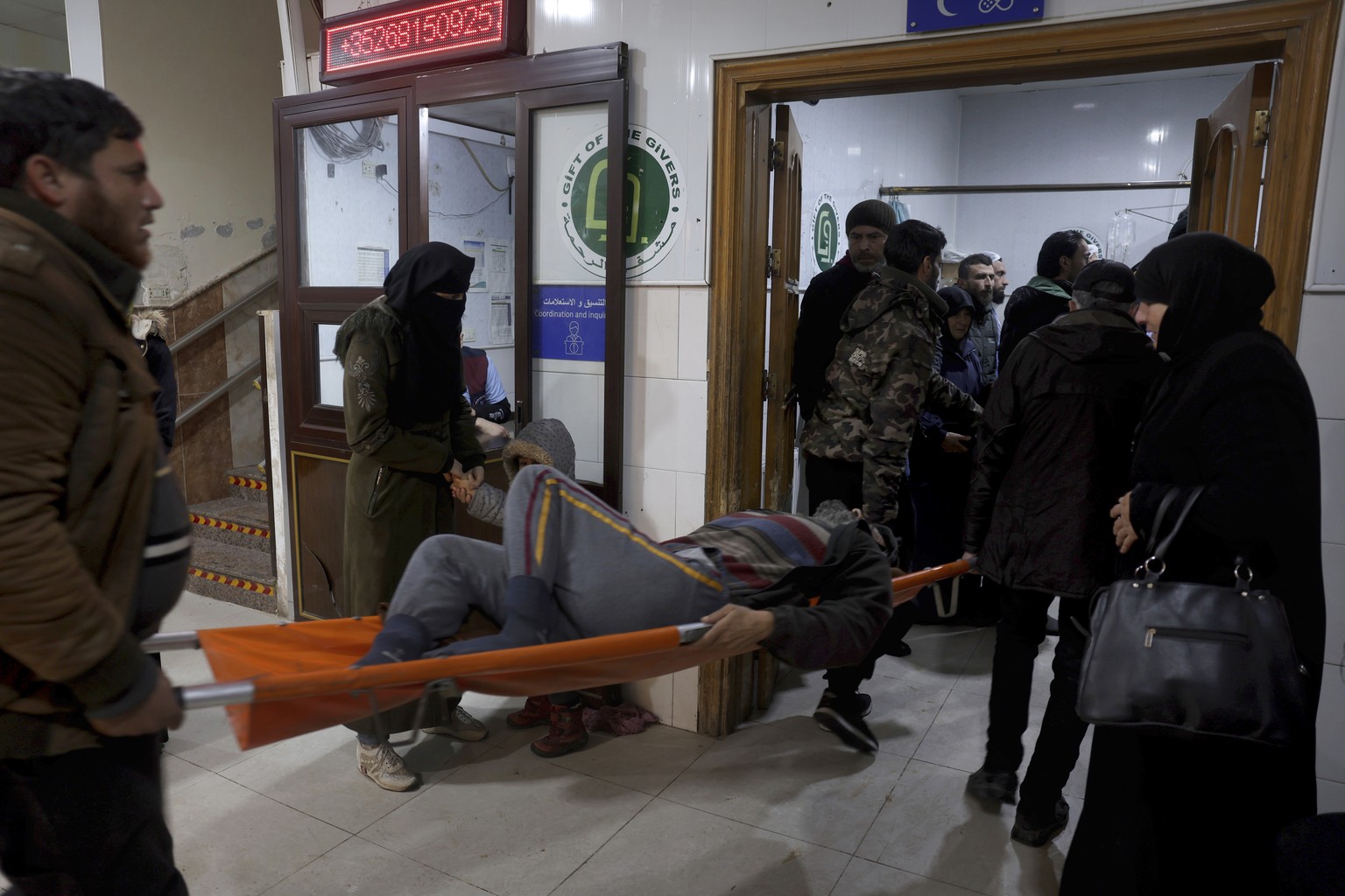 People carry a man injured in an earthquake into the al-Rahma Hospital in the town of Darkush, Idlib province, northern Syria, Monday, Feb. 6, 2023. A powerful earthquake has caused significant damage ...