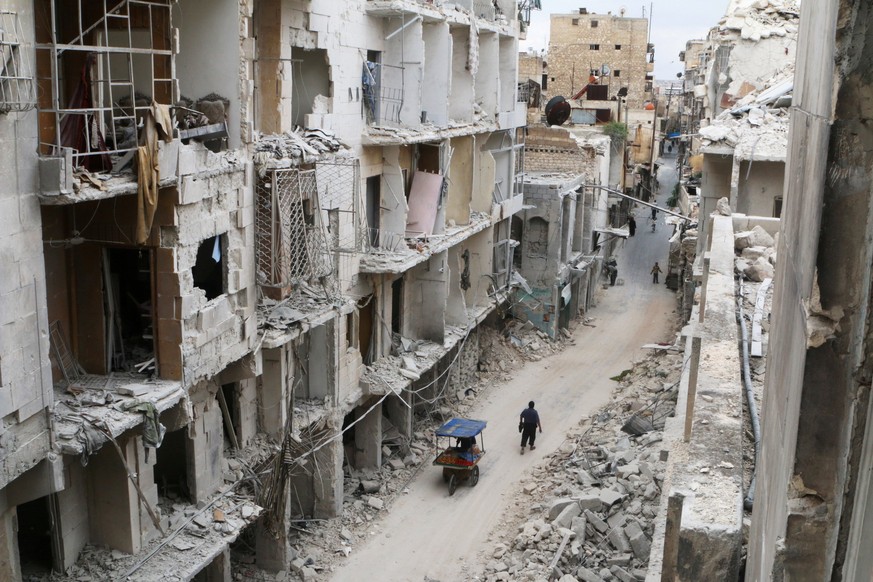 Residents walk near damaged buildings in the rebel held area of Old Aleppo, Syria May 5, 2016. REUTERS/Abdalrhman Ismail/File Photo