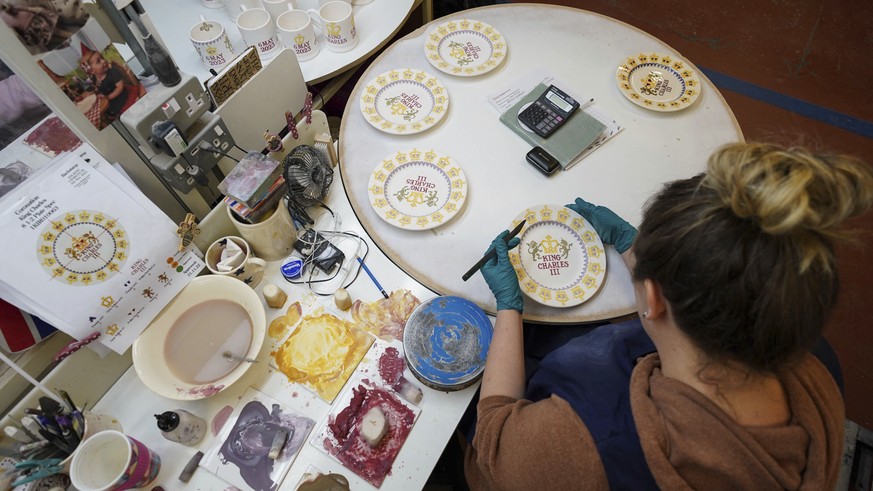 A pottery decorator adds detail to Britain&#039;s King Charles III themed plates, during the production of hand-decorated pieces from the forthcoming Coronation collection, at the Emma Bridgewater Pot ...