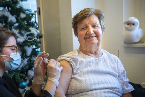 Une infirmiere donne la premiere dose du vaccin Pfizer-BioNTech a une residente fribourgeoise de l&#039;EMS La Residence Saint-Martin a l&#039;occasion du lancement de la vaccination contre le Sars-Co ...
