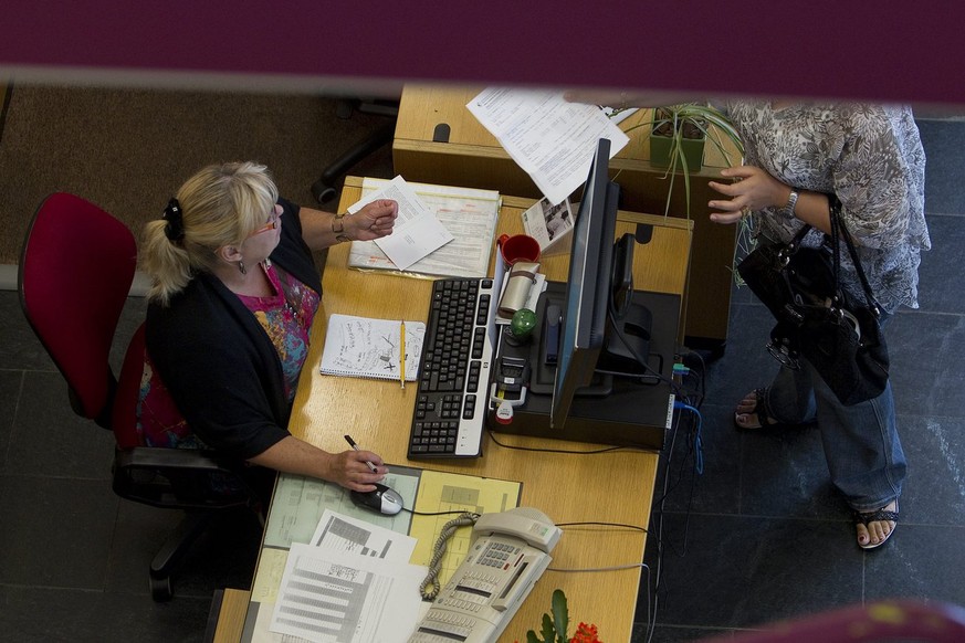 Une femme transmet un document a l&#039;une des receptionistes de l&#039;accueil du Centre d&#039;action sociale des Paquis de l&#039;Hospice general HG, ce mardi 14 septembre 2010 a Geneve. L’Hospice ...