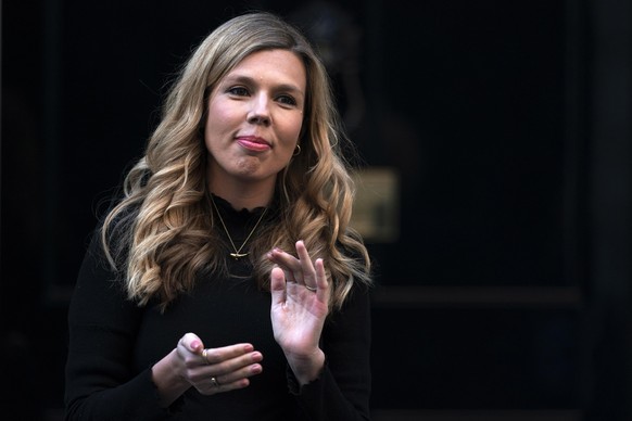 epa08422733 British Prime Minister Boris Johnson fiance Carrie Symonds takes part during the &#039;Clap for our Carers&#039; campaign in support of Britain&#039;s National Health Service (NHS) in 10 D ...