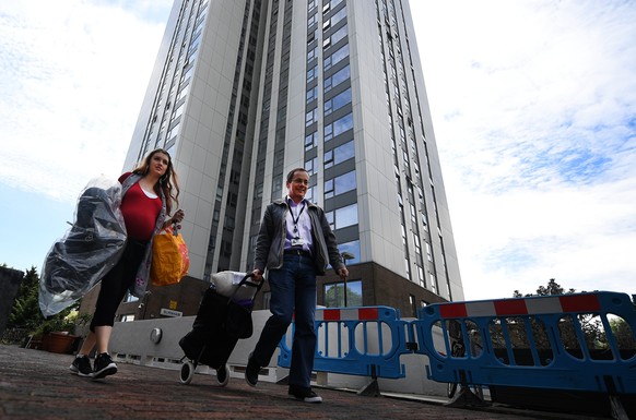 epa06051489 Residents leave their homes at Chalcots Estate in Camden, north London, Britain, 26 June 2017. Thousands of people have been evacuated from five tower blocks at the Chalcots Estate while c ...