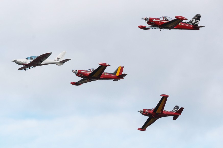 epa09696966 Belgian-British pilot Zara Rutherford in her small plane (L) is escorted by other aircraft as she approaches for landing in Wevelgem, Belgium, 20 January 2022. Zara, 19, broke the Guinness ...