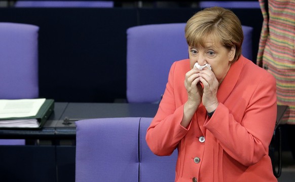 German Chancellor Angela Merkel blows her nose prior to a meeting of the German federal parliament, Bundestag, in Berlin, Germany, Thursday, June 18, 2015. (AP Photo/Michael Sohn)