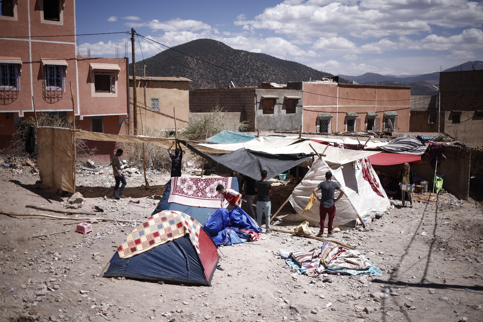 epa10852707 A group of young men set up a makeshift camp at an open area in Moulay Brahim, south of Marrakesh, Morocco, 10 September 2023, following a powerful earthquake. A magnitude 6.8 earthquake t ...