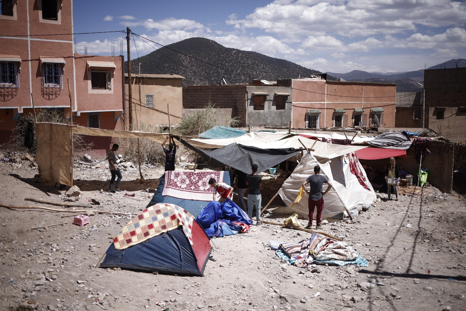 epa10852707 A group of young men set up a makeshift camp in a clearing in Moulay Brahim, south of Marrakesh, Morocco, on September 10, 2023, after a powerful earthquake.  An earthquake with a magnitude of 6.8...