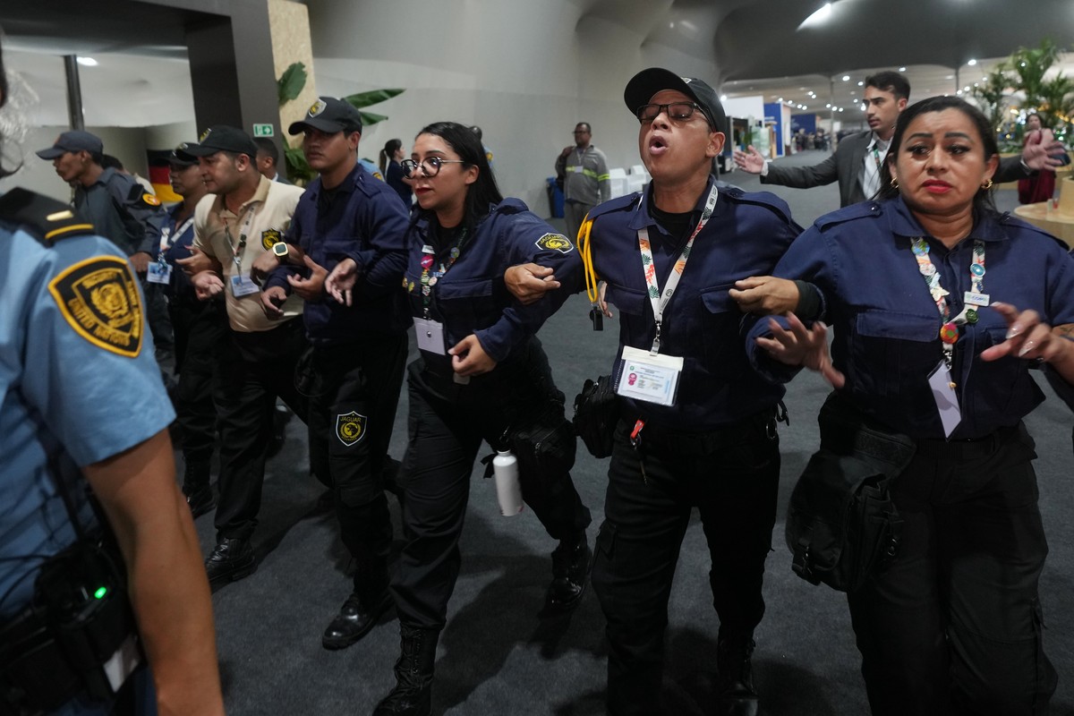 Officials form a chain to not allow attendees past after attendees were asked to leave the venue for the COP30 U.N. Climate Summit, Thursday, Nov. 20, 2025, in Belem, Brazil. (AP Photo/Andre Penner)
C ...