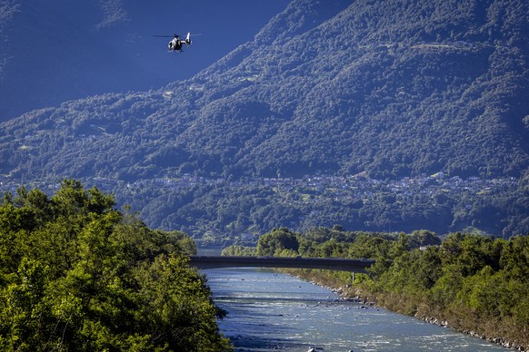 epa11457282 A police helicopter searches for missing bodies in the river Maggia in Locarno, southern Switzerland, 04 July 2024. Severe storms and torrential rain over the last weekend left five people ...