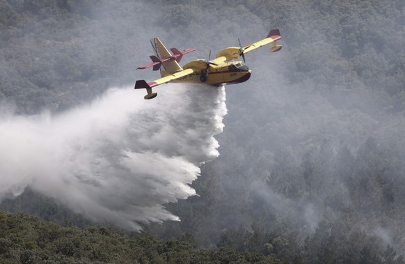 epa10014066 A Canadair firefighting aircraft drops water on a forest fire that started the previous night in Sierra de Leyre , Navarra region, Spain, 15 June 2022. A heatwave is currently sweeping thr ...