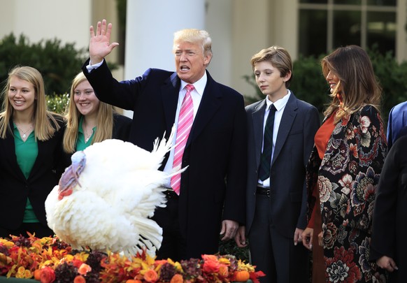 President Donald Trump with first lady Melania Trump, right, and their son Barron Trump, waves after pardoning the National Thanksgiving Turkey Drumstick during a ceremony in the Rose Garden of the Wh ...