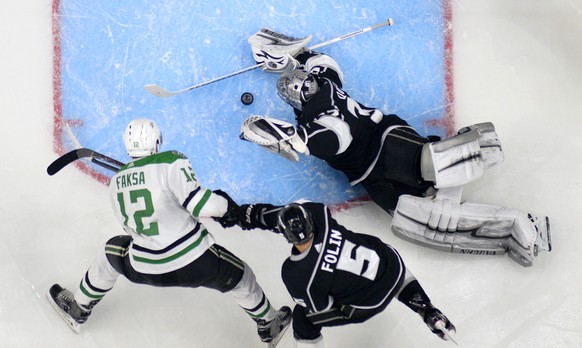 Los Angeles Kings goaltender Jonathan Quick, right, stops a shot by Dallas Stars center Radek Faksa, left, of the Czech Republic, as defenseman Christian Folin, of Sweden, helps Quick during the secon ...