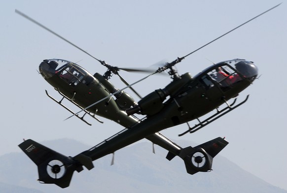 Montenegro army helicopters perform during an air show in Podgorica, Montenegro, Sunday, Oct. 12, 2014. (AP Photo/Risto Bozovic)