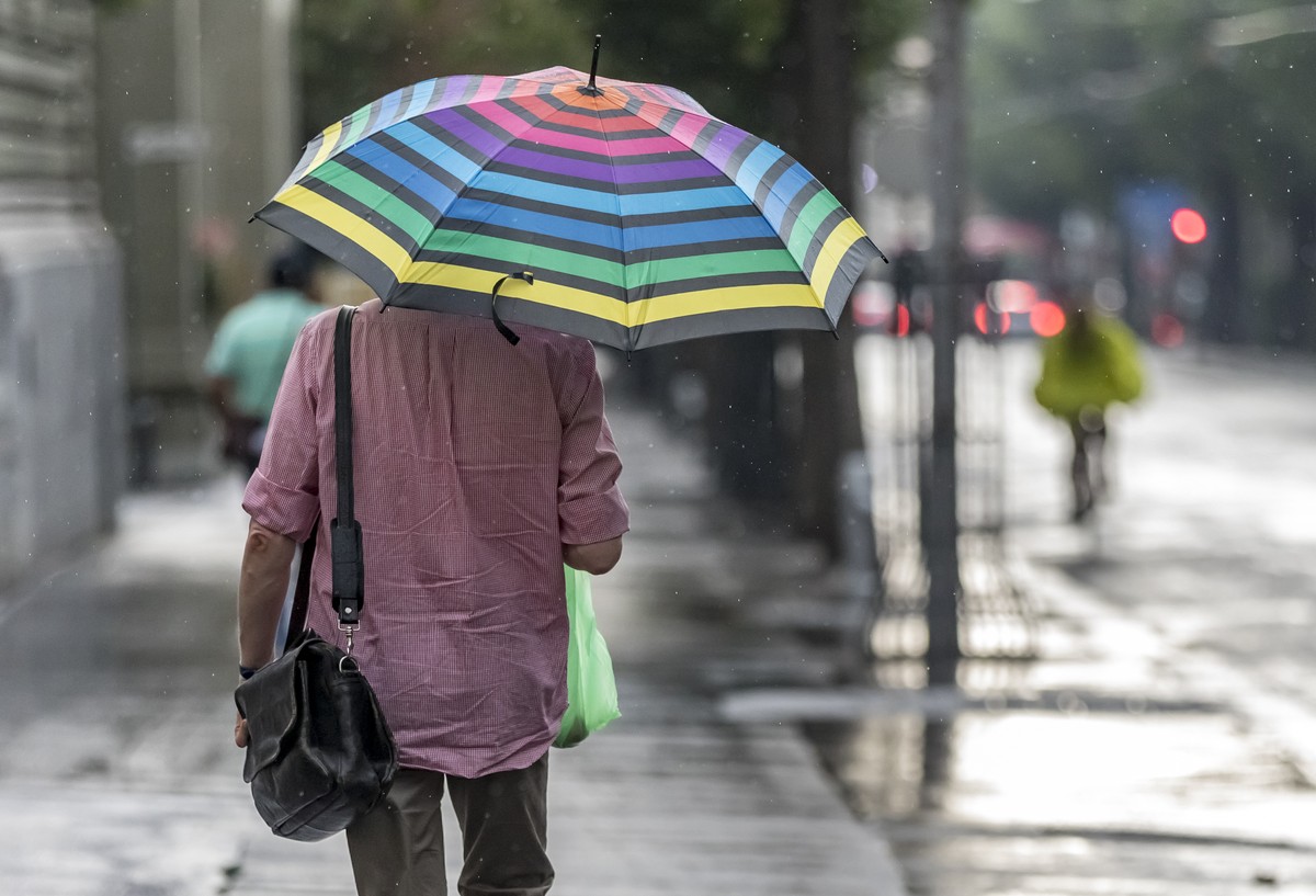 Ein Mann mit einem Schirm laeuft im Regen in Bern, am Mittwoch, 8. August 2018. (KEYSTONE/Thomas Hodel)