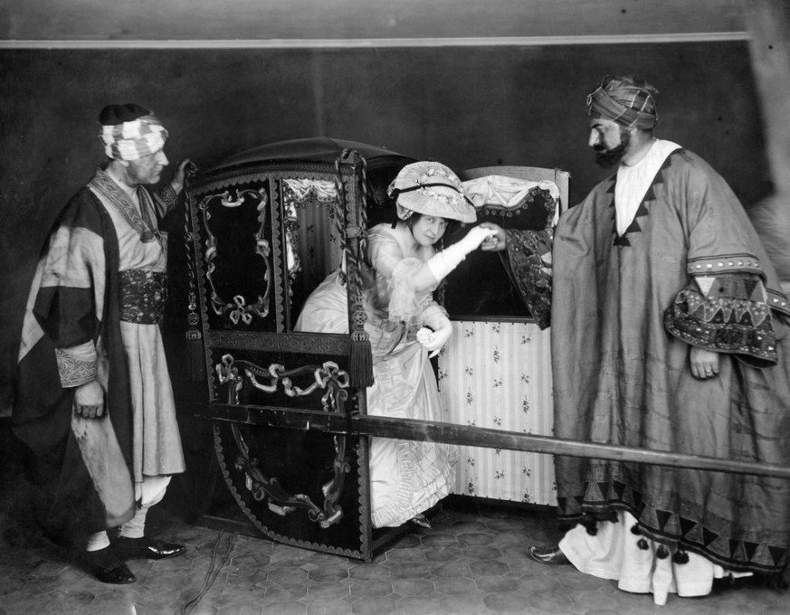 Mrs Fagan, the well known Chelsea artist arrives in a sedan chair, carried by Mr Jack ( the portrait painter) and Mr W Macbeth (also an artist) both dressed as Abyssinians. Chelsea Arts Club costume b ...