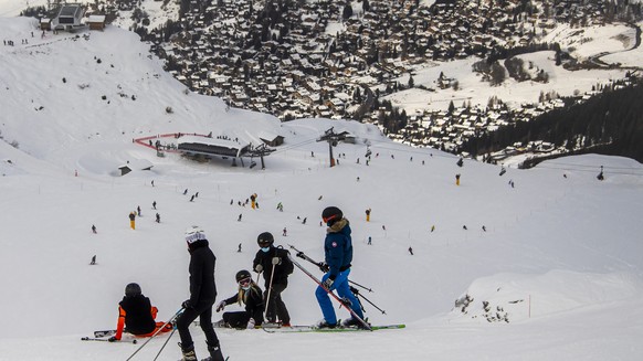 Des skieurs portant des masques chirurgicaux contre le Coronavirus (Covid-19) descendent une piste de ski le dimanche 26 decembre 2021 a Verbier dans le Val de Bagnes. (KEYSTONE/Jean-Christophe Bott)