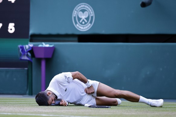 epaselect epa12227765 Novak Djokovic of Serbia falls on the ground during his Men&#039;s Singles quarter-finals match against Flavio Cobolli of Italy at the Wimbledon Championships, Wimbledon, Britain ...