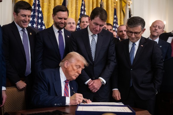 epa12245960 US President Donald J. Trump (sitting) signs the bill the cryptocurrency legislation Genius Act in the East Room of the White House in Washington, DC, USA, 18 July 2025. EPA/FRANCIS CHUNG  ...