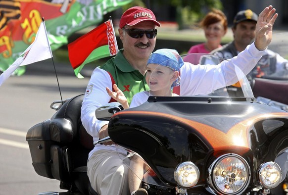 Belarusian President Alexander Lukashenko rides a Harley Davidson motorbike with his youngest son, Nikolai, in his lap through the capital Minsk on Saturday July 18, 2009. The hardline president of Be ...