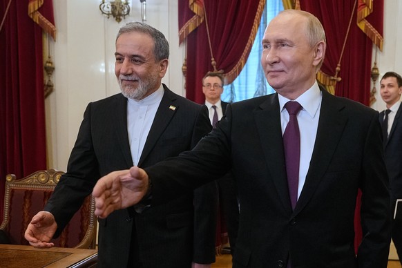 Russian President Vladimir Putin, right, and Iranian Foreign Minister Abbas Araghchi walk to attend the talks at the Boris Yeltsin Presidential Library, in St. Petersburg, Russia, Monday, April 27, 20 ...