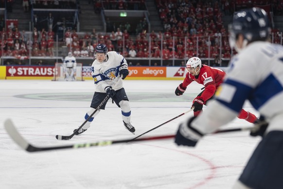 Finland's Konsta Helenius, left, scores the winning goal in overtime against Switzerland's Ken Jager, during the 2026 IIHF Men's Ice Hockey World Championship gold medal game between Sw ...
