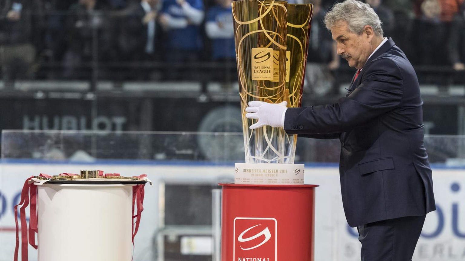 Der Leiter Spielbetrieb der Nationalliga, Willi Voegtlin richtet den Meisterpokal fuer die Siegerehrung nach dem sechsten Eishockey Playoff-Finalspiel der National League A zwischen dem EV Zug und dem ...