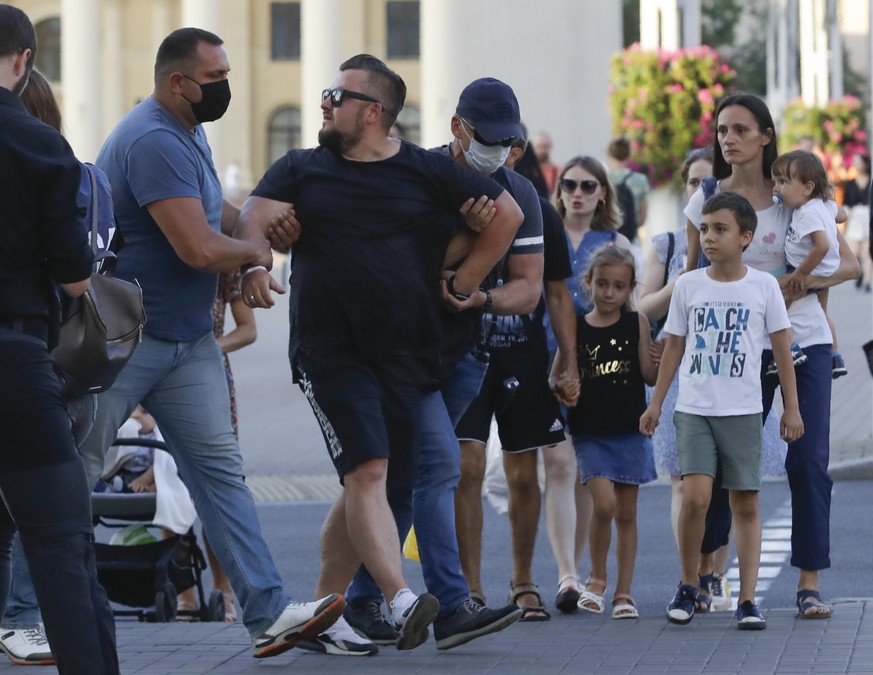 Belarusian police officers detain a man in Minsk, Belarus, Saturday, Aug. 8, 2020. On Saturday evening, police arrested at least 10 people as hundreds of opposition supporters drove through the center ...