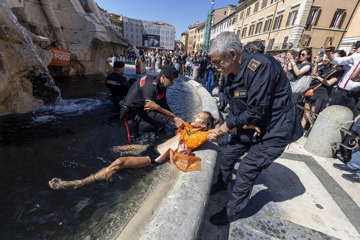 epa10612777 A Last Generation activist is detained after throwing a black liquid at the Bernini fountain in Piazza Navona, Rome, Itay, 06 May 2023. The action aimed to raise 'the alarm about the  ...