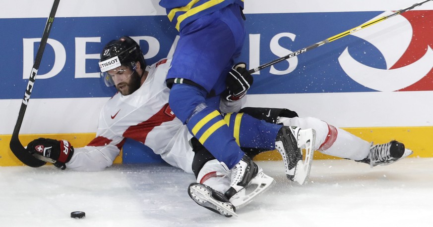 Sweden&#039;s John Klingberg, front, checks Switzerland&#039;s Dominik Schlumpf, back, during the Ice Hockey World Championships quarterfinal match between Switzerland and Sweden in the AccorHotels Ar ...